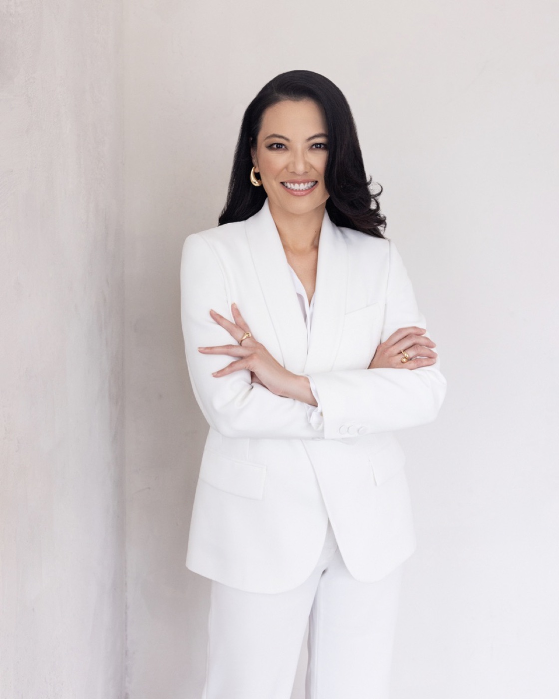 Dr. Justine C. Lee in a white suit, studio portrait